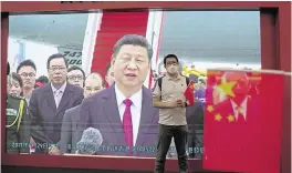  ?? ?? A visitor poses for a photograph in front of a TV showing Chinese President Xi Jinping at an exhibition in Hong Kong on Friday.