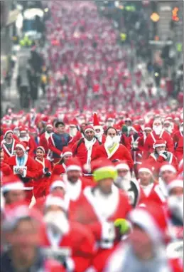  ?? JEFF J. MITCHELL / GETTY IMAGES ?? More than 8,000 members of the public take part in the annual Santa Dash on Sunday in Glasgow, Scotland. The event has been held since 2006 and has raised about 200,000 pounds ($267,000) for charities.