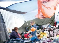  ??  ?? Los migrantes que buscan ingresar a Estados Unidos esperan el inicio de sus trámites, en un campamento cerca del cruce fronterizo de San Ysidro.