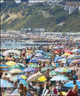  ?? AP ?? Crowds gather on the beach in Bournemout­h during a heatwave in England on Thursday.