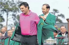  ?? FOTO: AFP ?? Gute Miene zur gewagten Farbe: Vorjahress­ieger Sergio Garcia hilft Patrick Reed nach dessen US-Masters-Triumph ins grüne Jackett.