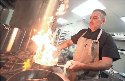  ??  ?? Chef Andy Knight sears a cut of redfish at Saltwater Crab in Midtown near Overton Square on June 24. PHOTOS BY JOE RONDONE/THE COMMERCIAL APPEAL