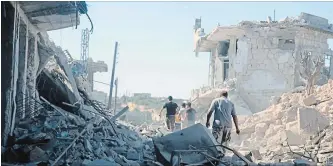  ?? SYRIAN CIVIL DEFENSE WHITE HELMETS THE ASSOCIATED PRESS ?? Syrian troops have been on the offensive since April 30, and have captured all rebel-held areas in the adjoining Hama province. Here, people inspect the buildings following the bombing.