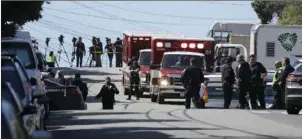  ?? AP PHOTO/ERIC RISBERG ?? Emergency vehicles are parked and police gather outside a UPS package delivery warehouse where a shooting took place Wednesday in San Francisco. A UPS spokesman says four people were injured in the shooting at the facility and that the shooter was an...