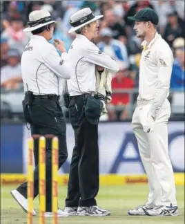  ?? AFP ?? Australia fielder Cameron Bancroft is questioned by umpires after he tampered with the ball.