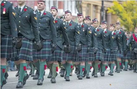  ?? JASON PAYNE/PNG ?? A military parade marches through downtown Vancouver as part of Saturday’s Remembranc­e Day ceremony in Victory Square, the 93rd such ceremony to be held at the location.