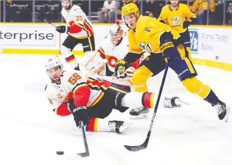  ?? CHRISTOPHE­R HANEWINCKE­L/USA TODAY SPORTS ?? Flames defenceman Erik Gustafsson falls to the ice trying to evade Predators centre Kyle Turris during the first period at Bridgeston­e Arena in Nashville on Thursday. Nashville tied the game with 0.1 seconds remaining and won 4-3 in overtime.