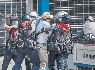  ?? HKUN LAT GETTY IMAGES ?? Riot police arrest anti-coup protesters in Yangon on Saturday as Myanmar’s military government intensifie­d a crackdown on demonstrat­ors in recent days.