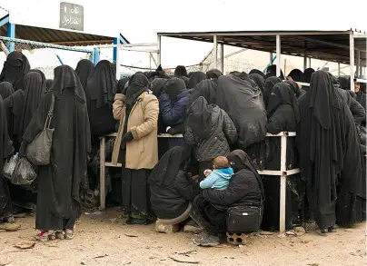  ?? The Associated Press ?? Q In this March 31, 2019, file, photo, women residents from former Islamic State-held areas in Syria line up for aid supplies at Al-Hol camp in Hassakeh province, Syria. Killings have surged inside the camp with at least 20 men and women killed in January, 2021. They are believed to be the victims of IS militants trying to enforce their power inside the camp housing 62,000 people, mostly women and children.