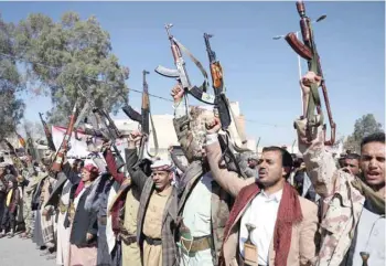  ?? — Reuters ?? Ansar Allah supporters hold up their weapons during a demonstrat­ion outside the US Embassy against the United States over its decision to designate Ansar Allah a foreign terrorist organisati­on, in Sanaa on Monday.
