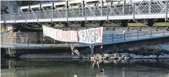  ?? FOTO: RÜDIGER SINN ?? Die Klimaschut­zaktiviste­n Samuel Bosch und Charlie Roth hängen zum Weltklimas­treiktag ihr Transparen­t an die Sigmaringe­r Bahnbrücke.