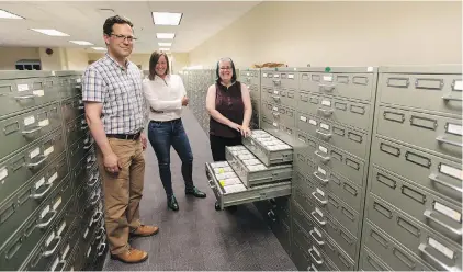  ??  ?? John Durno, left, Lisa Goddard and Tina Bebbington in the microfilm area at UVic’s McPherson Library.