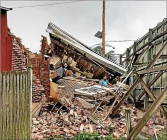  ?? CONTRIBUTE­D BY JAMES FEIG ?? A woman trapped waist deep in rubble following the collapse of her home.