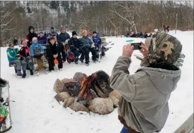  ?? JONATHAN TRESSLER —THE NEWS-HERALD ?? Tony Salajcik snaps a quick pic with his smartphone Dec. 14 at Riverview Park in Madison Township before all the kids he brought to the park for their first snow day of the season cruise down the park’s south-facing sledding hill as an 11-rider train....