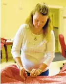  ??  ?? Stacy Kehoe, a member of Judge David Campbell Daughters of the American Revolution, cuts fabric for miniature tree skirts.