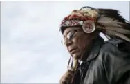  ?? DAVID GOLDMAN — THE ASSOCIATED PRESS FILE ?? Chief Arvol Looking Horse, a spiritual leader of the Great Sioux Nation puts on his headdress for an interfaith ceremony at the Oceti Sakowin camp where people have gathered to protest the Dakota Access oil pipeline in Cannon Ball, N.D.