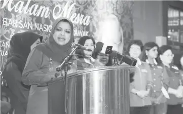  ??  ?? Shahrizat speaking at the dinner, accompanie­d by her comrades from BN component parties in Peninsular Malaysia, Sabah and Sarawak. — Photo by Chimon Upon