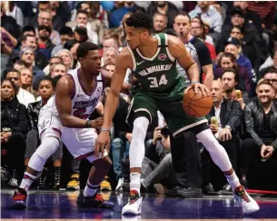  ?? MARK BLINCH NBAE VIA GETTY IMAGES ?? Bucks star Giannis Antetokoun­mpo was held to just 14 field-goal attempts and eight foul shots by Kyle Lowry and the Raptors on Tuesday night.