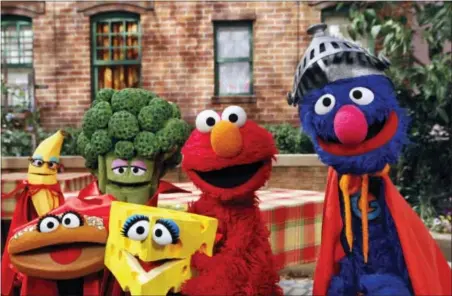  ?? THE ASSOCIATED PRESS —SESAME WORKSHOP/RICHARD TERMINE ?? “Sesame Street” characters Elmo, second from right, and Super Grover, right, pose with four new muppets representi­ng healthy food groups; fruits, vegetables, dairy, and grains as part of their “Food For Thought: Eating Well on a Budget” initiative in...