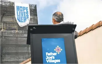  ?? SANDY HUFFAKER U-T FILE PHOTO ?? Father Joe’s Villages President and CEO Deacon Jim Vargas watches the unveiling of a banner reading “Hope Lives Here” during constructi­on of the Saint Teresa of Calcutta Villa project in April 2021.