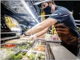  ?? JIM NOELKER / STAFF ?? Gem City Market Deli Manager Chris Bender puts together a lunch salad bar at the market on Tuesday.