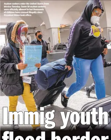  ??  ?? Asylum seekers enter the United States from Mexico Tuesday. Some 50 asylum seekers were officially allowed in but thousands of children have crossed illegally since President Biden took office.