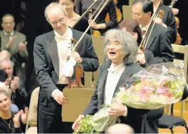  ?? KYODO NEWS USA TODAY NETWORK ?? Japanese conductor Seiji Ozawa receives a bouquet of flowers after his last performanc­e with the Boston Symphony Orchestra in Boston in April 2002.