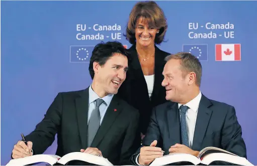  ??  ?? Le premier ministre, Justin Trudeau, signe officielle­ment l’AECG en compagnie du président du Conseil européen, Donald Tusk, le 30 octobre, à Bruxelles.