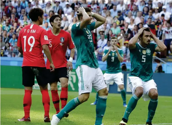  ??  ?? Mario Gomez, center, and Germany’s Mats Hummels, right, hold their heads after failing to score during the group F match between South Korea and Germany, at the 2018 soccer World Cup in the Kazan Arena in Kazan, Russia, Wednesday, June 27, 2018.