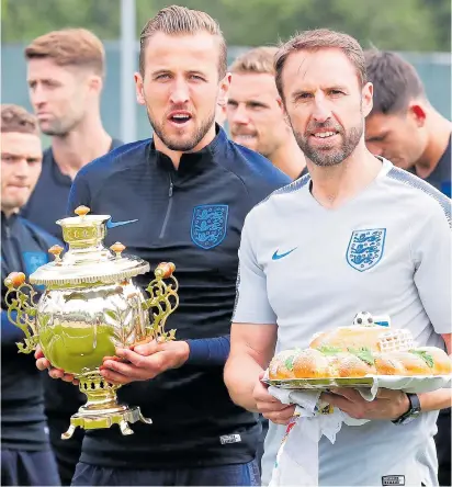  ??  ?? England captain Harry Kane and manager Gareth Southgate are presented with tea and bread yesterday