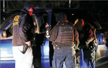  ?? STEVE HELBER — THE ASSOCIATED PRESS ?? In this photo U.S. Immigratio­n and Customs Enforcemen­t agents surround and detain a person during a raid in Richmond, Va.