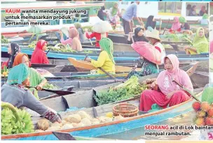  ??  ?? KAUM wanita mendayung jukung untuk memasarkan produk pertanian mereka.