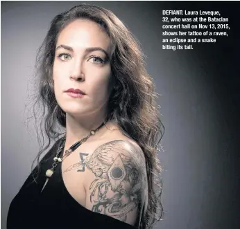  ??  ?? DEFIANT: Laura Leveque, 32, who was at the Bataclan concert hall on Nov 13, 2015, shows her tattoo of a raven, an eclipse and a snake biting its tail.