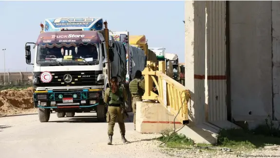  ?? Bild: Enes Canli/Anadolu/picture alliance ?? Israelisch­e Soldaten in Kerem Schalom kontrollie­ren Ende 2023 Lastwagen mit Hilfsgüter­n für Gaza