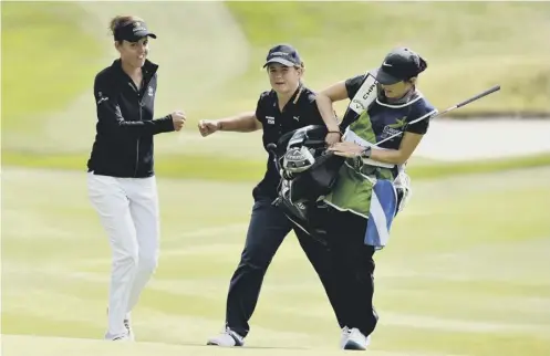  ??  ?? Michele Thomson, centre, and Meghan Maclaren, left, fist bump after the former’s chip on the 18th which helped secure a vital half point.