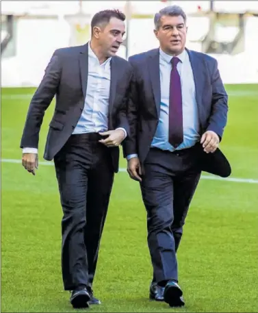  ?? ?? Xavi y Joan Laporta, en el césped del Camp Nou.