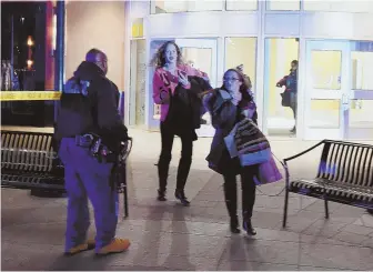  ?? HERALD PHOTOS BY JIM MICHAUD ?? RUNNING FOR COVER: Shoppers, above, flee South Shore Plaza after being cleared to leave the Braintree mall last night. Police ringed the shopping center and conducted a store-by-store search for the gunman who shot at a suspected rival gang member....