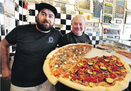  ??  ?? Franco Bastone, right, with manager Jonathan Oporto, of Nat’s New York Pizzeria, is concerned about rising gas prices, and is hoping they will stabilize or go down in summer.