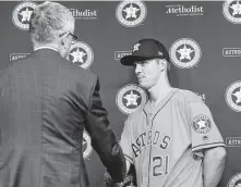  ?? Steve Gonzales / Staff photograph­er ?? Astros general manager Jeff Luhnow shakes hands with Zack Greinke on Friday.