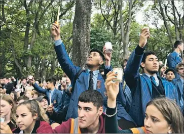  ?? Anthony Wallace AFP/Getty Images ?? STUDENTS attend a vigil in Christchur­ch, New Zealand, to honor victims of the attack on two mosques in the city. It’s “important to show everyone that one act of violence doesn’t define a whole city,” said one participan­t.