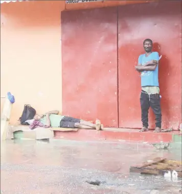  ??  ?? The street dweller on the left was oblivious to the rising flood around him