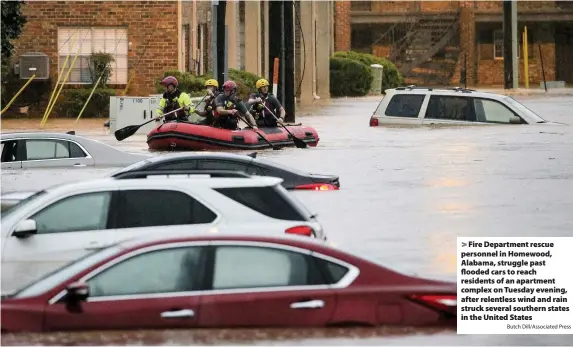  ?? Butch Dill/Associated Press ?? Fire Department rescue personnel in Homewood, Alabama, struggle past flooded cars to reach residents of an apartment complex on Tuesday evening, after relentless wind and rain struck several southern states in the United States