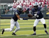  ?? JENNIFER FORBUS — FOR THE MORNING JOURNAL ?? Titan quarterbac­k Joseph Wyatt hands off to running back Robert Gonzalez.