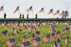  ?? J. SCOTT APPLEWHITE/ ASSOCIATED PRESS ?? Activists from the COVID Memorial Project mark the deaths of 200,000 lives lost in the U.S. to COVID-19 after placing thousands of small American flags on the grounds of the National Mall in Washington, D.C., on Tuesday.