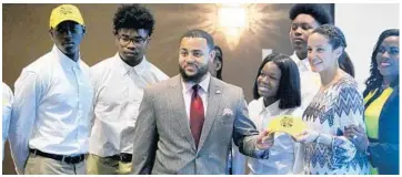  ?? JOE BURBANK/STAFF PHOTOGRAPH­ER ?? Reginald Burroughs, center, coordinato­r for Orlando’s Parramore Kidz Zone and founder of the student-run Black Bee Honey, joins community leaders and students Wednesday for a watch party of a “Steve” segment about them.