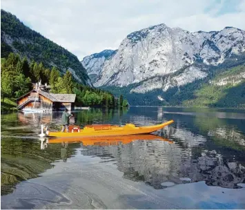  ?? Foto: Lilo Solcher ?? Fast schon kitschig schön: Felix Suchanek mit seiner „Plätte“auf dem Altausseer See, in dem sich die Berge spiegeln. Auch die holländisc­he Königsfami­lie hat diesen Blick genossen.