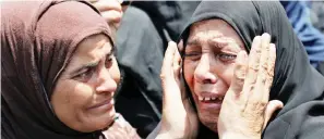  ??  ?? سيدتان مصريتان تبكيان أمس أثناء تشييع أحد ضحايا العملية اإلرهابية في سيناء. (رويترز)