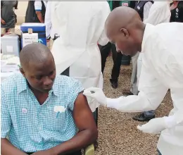  ?? YOUSSOUF BAH/THE ASSOCIATED PRESS ?? A health worker, right, cleans a man’s arm before injecting him with an Ebola vaccine in Conakry, Guinea in 2015. CEPI wants to prepare vaccines for three viruses, MERScorona­virus, Lassa, and Nipah.