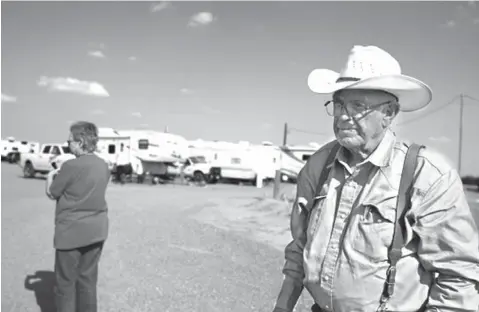  ?? James Durbin/Midland Reporter-Telegram via AP ?? ■ Ted and Murlene Godfrey walk through the RV park they own on July 31 near Pecos. Texas. The Godfreys have nearly tripled the size of their RV park, and people are still clamoring to live there.