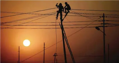  ??  ?? ALLAHABAD: Indian workers adjust electricit­y cables set up temporaril­y on the banks of the river Ganga in preparatio­n for the annual Hindu religious fair of Magh Mela yesterday. — AFP